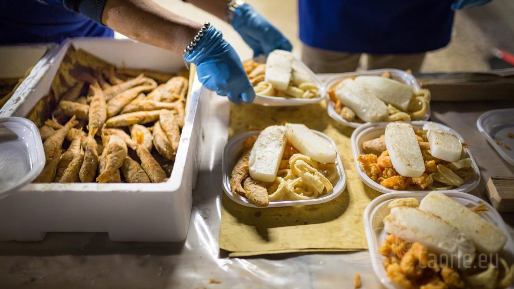Piatti tipici di pesce fritto alla Festa del Pesce di Caorle, specialità culinarie vicino all'Hotel All'Orologio.