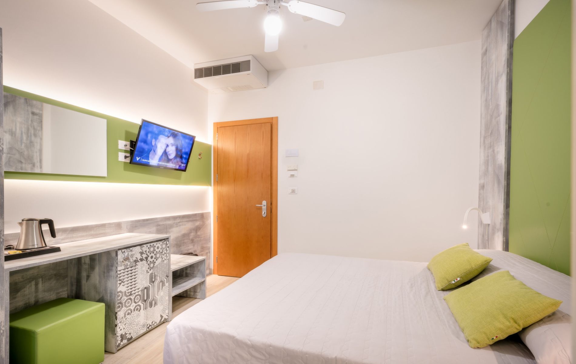 Dettaglio arredi moderni della camera Ananas & Kiwi presso l'Hotel All'Orologio di Caorle, focus sulla luminosità e il design contemporaneo.