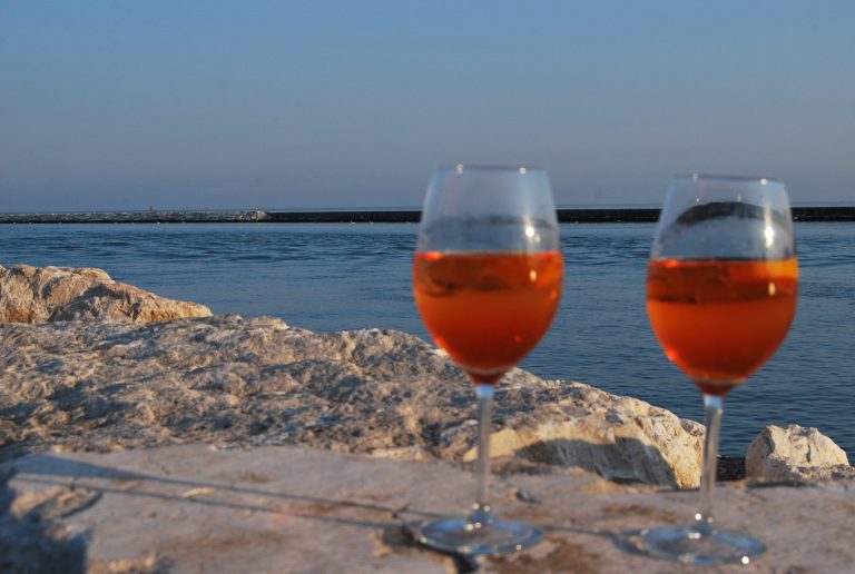 Aperitif pillanatok Caorléban italokkal és falatkákkal, esti kikapcsolódás a Hotel All'Orologio közelében.