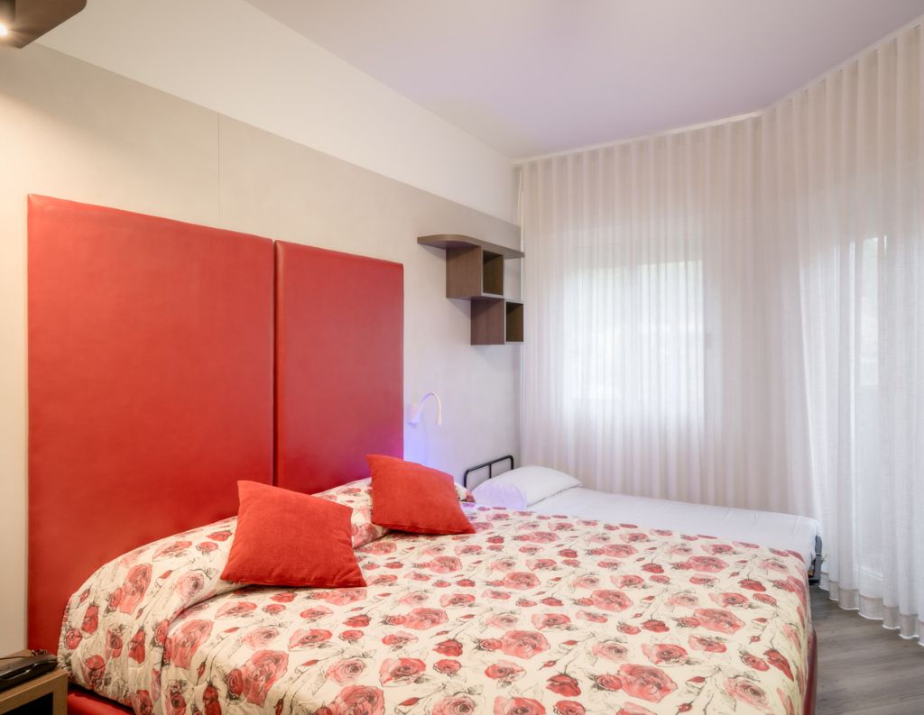 Hotel Caorle All'Orologio Camera matrimoniale Cherry Plus dell'Hotel All'Orologio a Caorle con arredamento moderno, colori caldi e finiture di pregio.