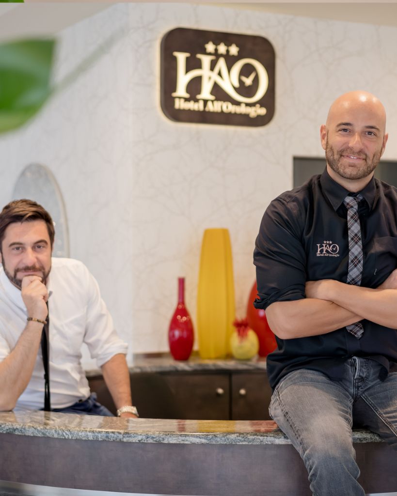 Gilberto e Alessio accolgono gli ospiti alla reception dell'Hotel All'Orologio a Caorle.