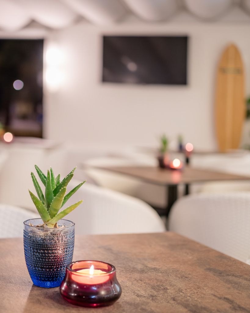Tavolino moderno del bar dell'Hotel All'Orologio a Caorle con sedie di design e atmosfera accogliente per colazioni e aperitivi.