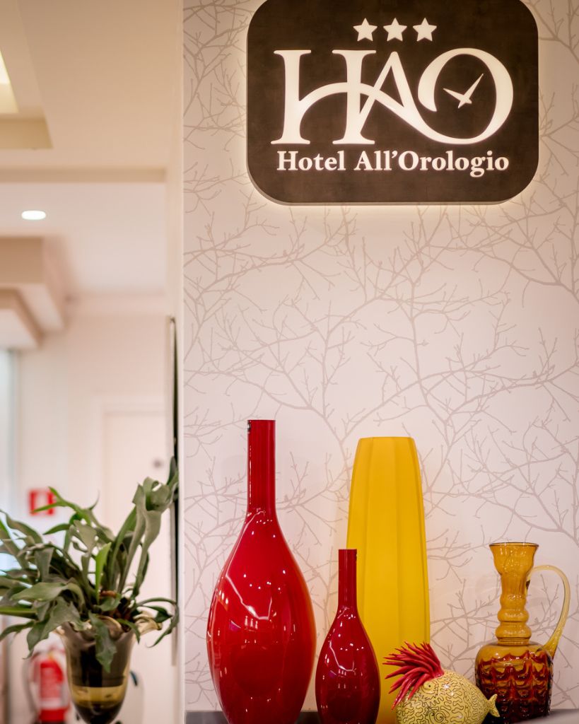 Dettaglio d'arredo moderno: vaso in vetro di Murano giallo brillante su base di design presso la hall dell'Hotel All'Orologio a Caorle.
