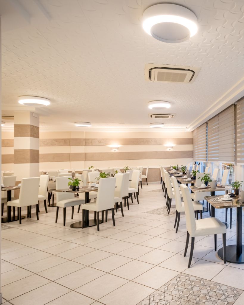 Dettaglio dei tavoli nella sala colazione dell'Hotel All'Orologio a Caorle, con arredi moderni in stile minimalista e atmosfera luminosa.