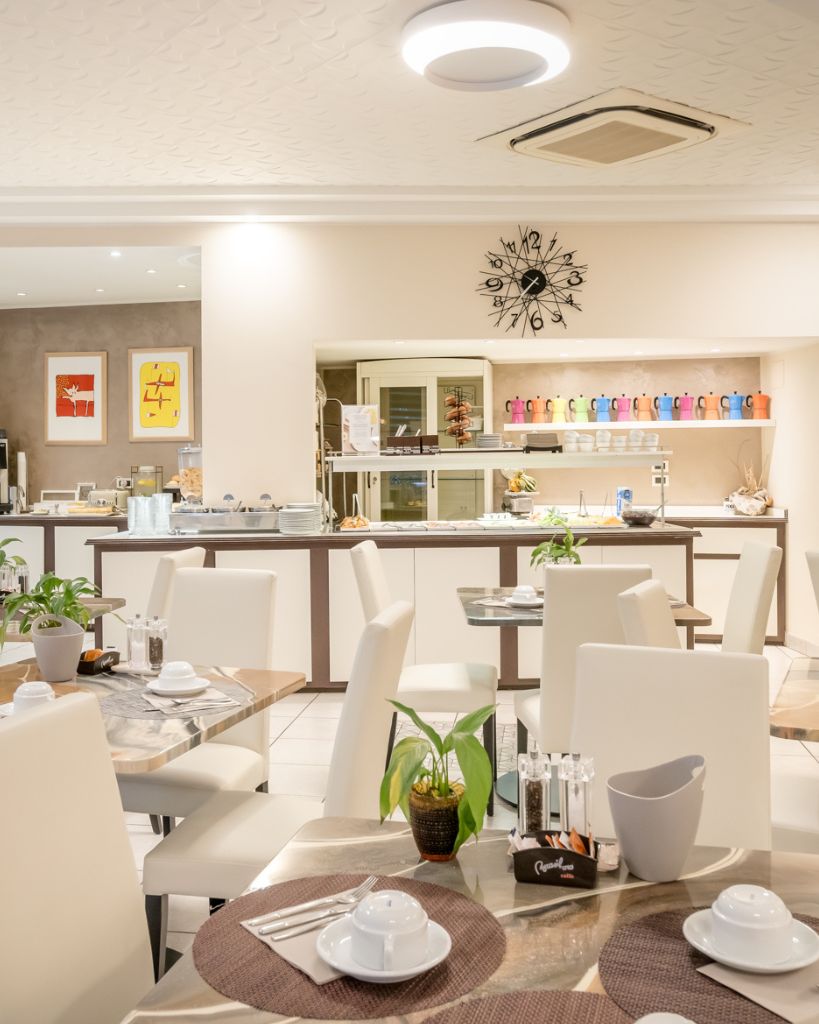 Dettaglio di tazzine colorate per il caffè durante la colazione all'Hotel All'Orologio a Caorle, stile moderno e vivace.