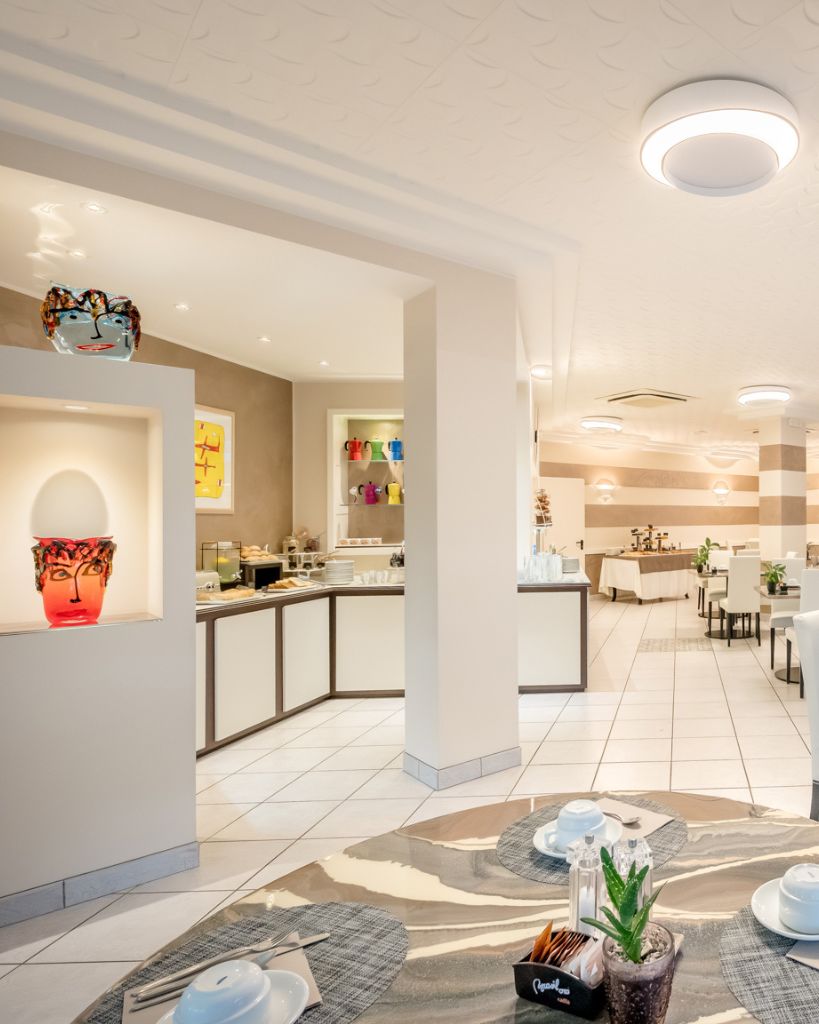 Dettaglio d'arredo artistico nella sala colazione dell'Hotel All'Orologio a Caorle: vaso di design a forma di faccia con richiami al vetro di Murano.