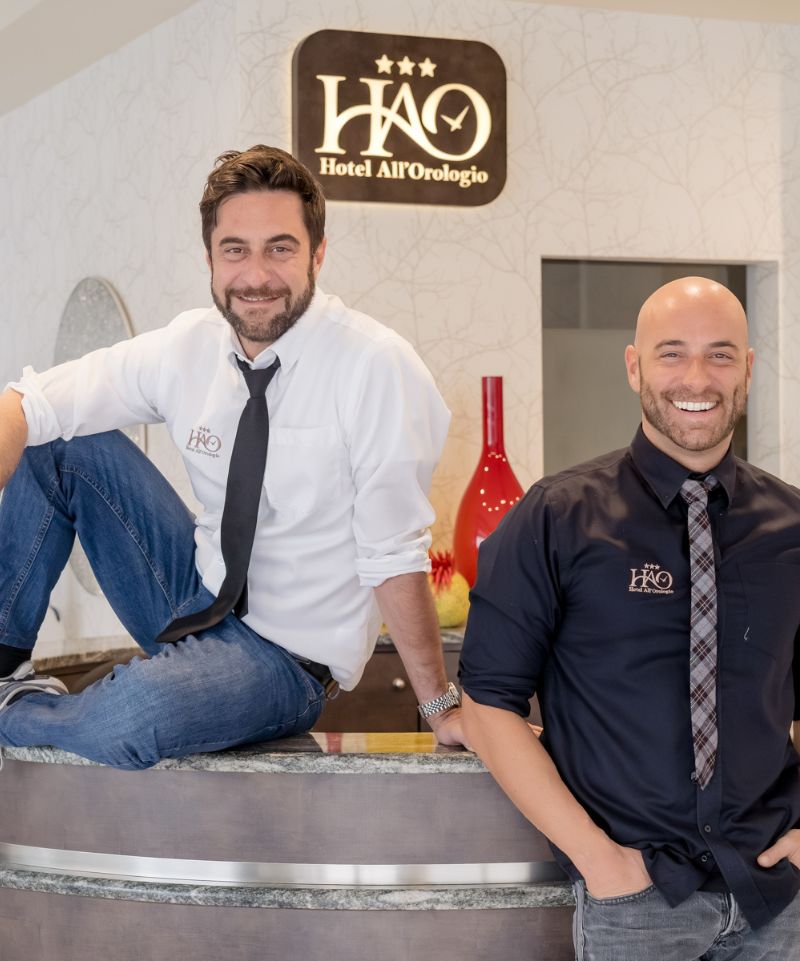Hotel Caorle All'Orologio Gilberto e Alessio sorridenti alla reception dell'Hotel Orologio a Caorle.