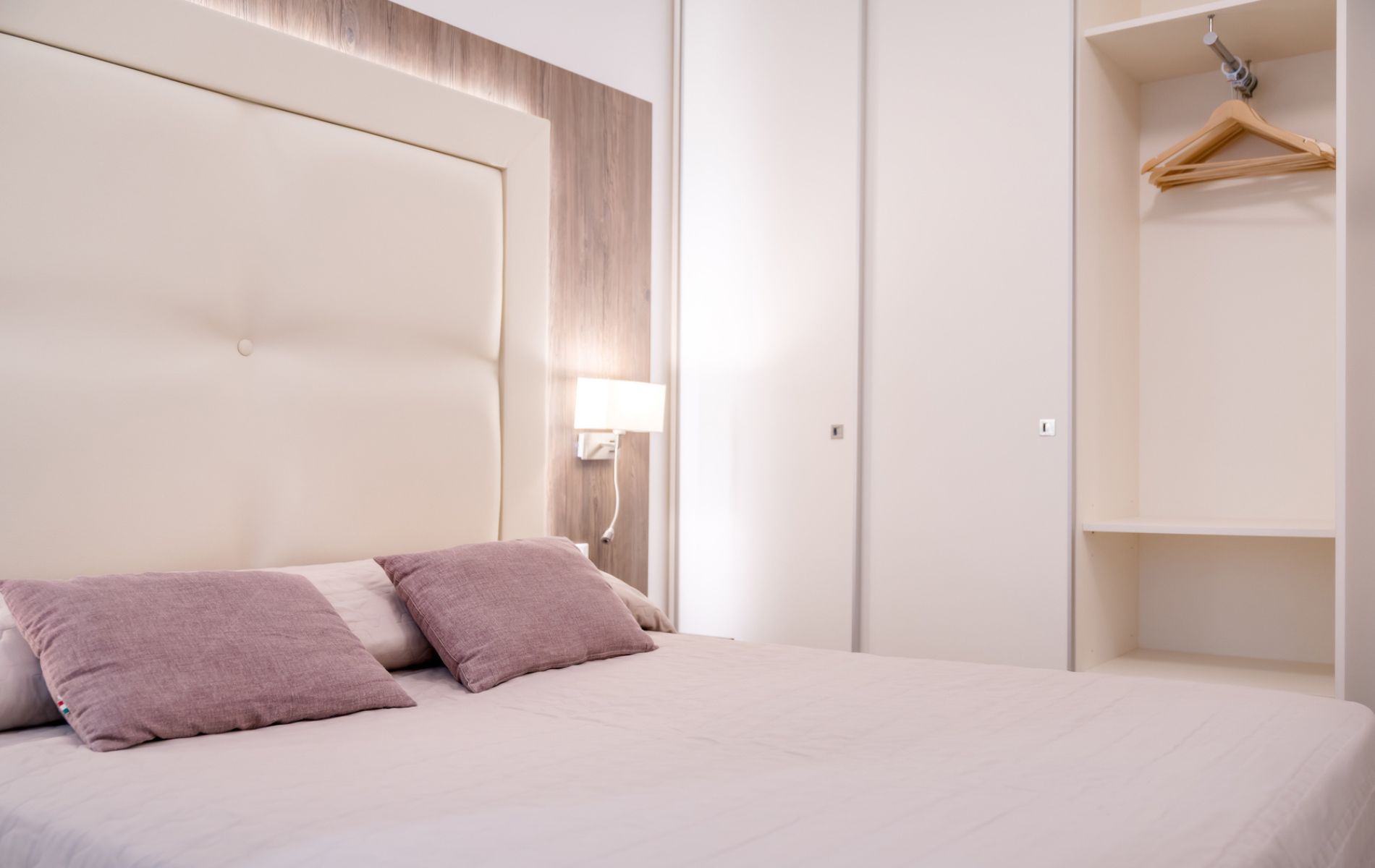 Hotel Caorle All'Orologio Vista panoramica della camera Harmony all'Hotel All'Orologio di Caorle, con letto matrimoniale rifatto e arredamento moderno in toni chiari.