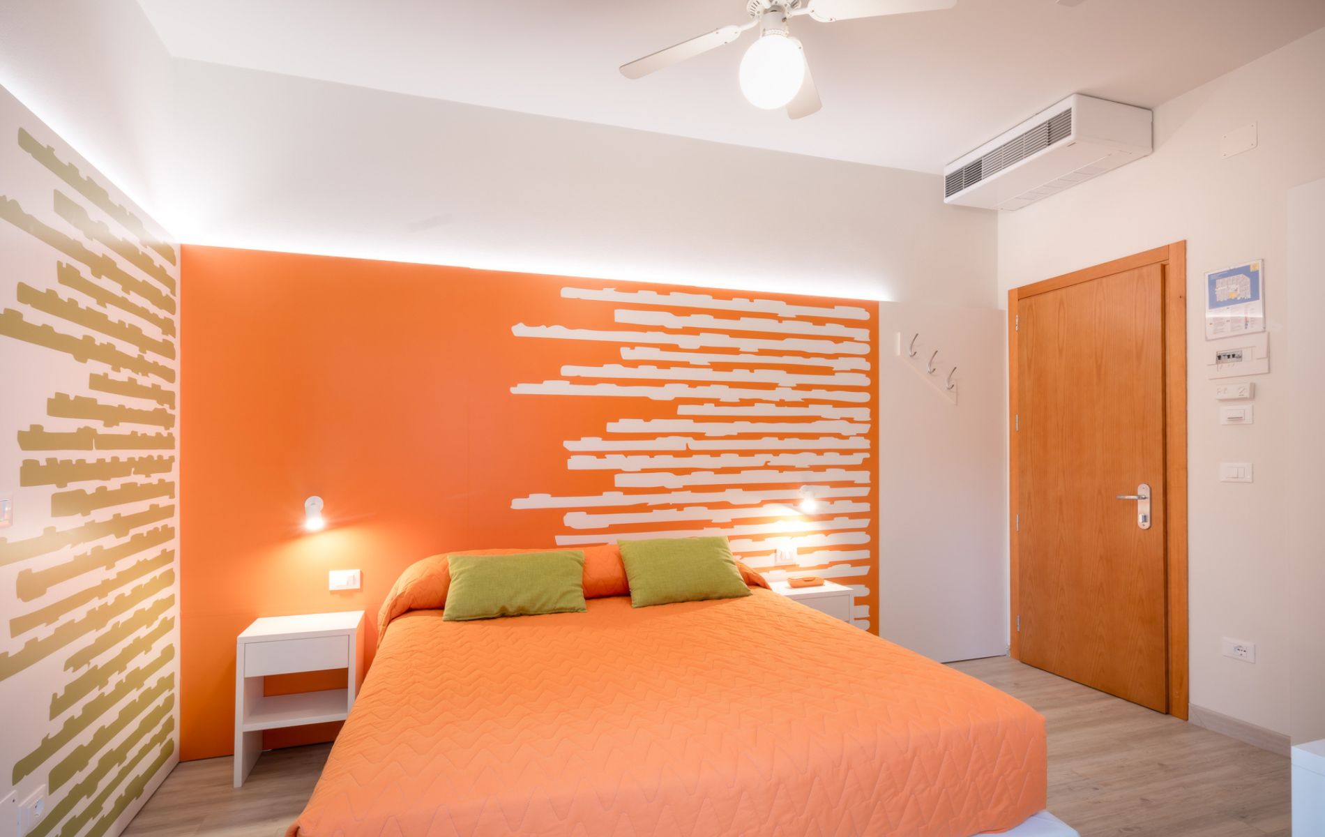 Dettaglio degli arredi e dell'illuminazione nella Camera Papaya dell'Hotel Orologio a Caorle.