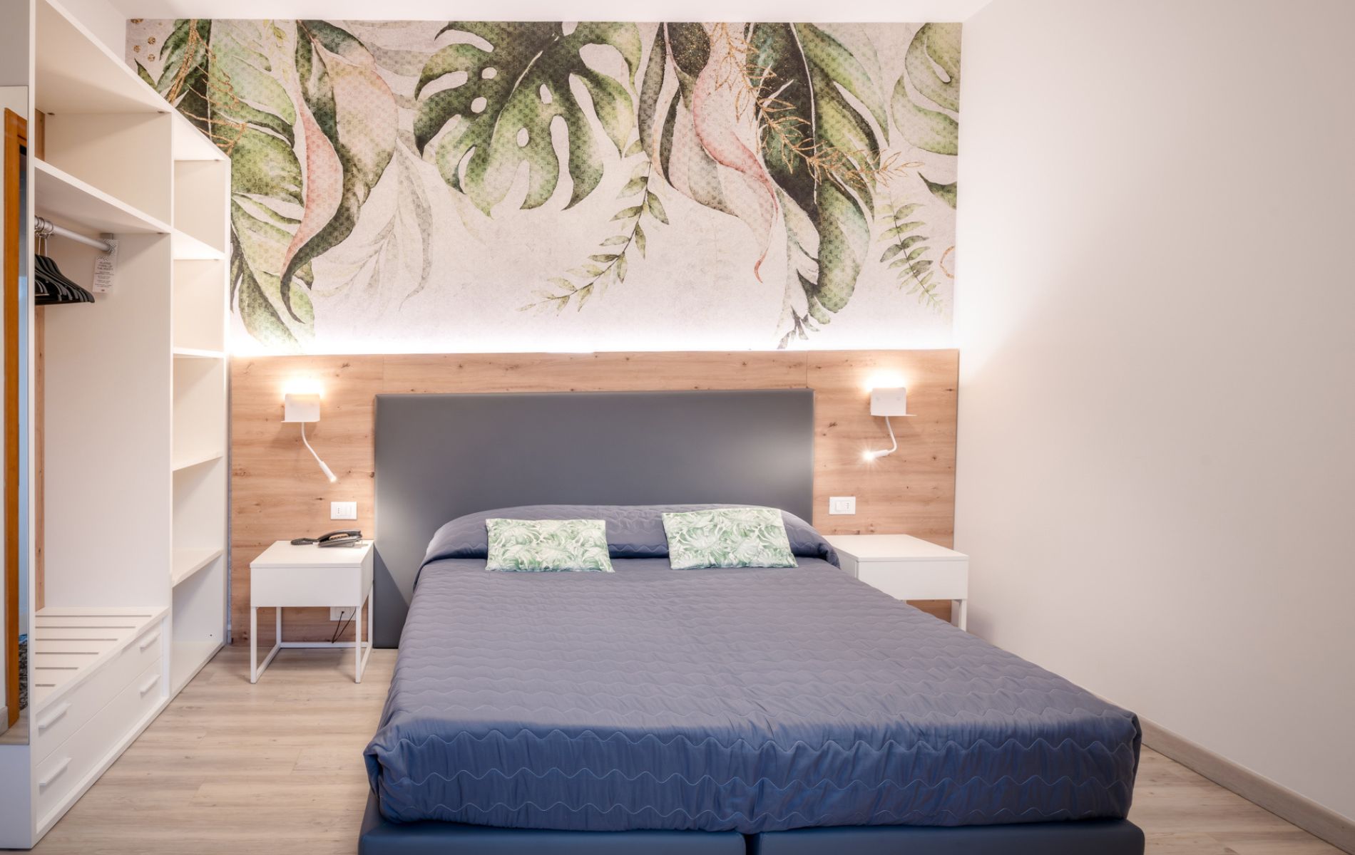 Dettaglio degli arredi e della zona notte della camera Tropical presso l'Hotel All'Orologio di Caorle, con finiture in legno e atmosfera estiva.