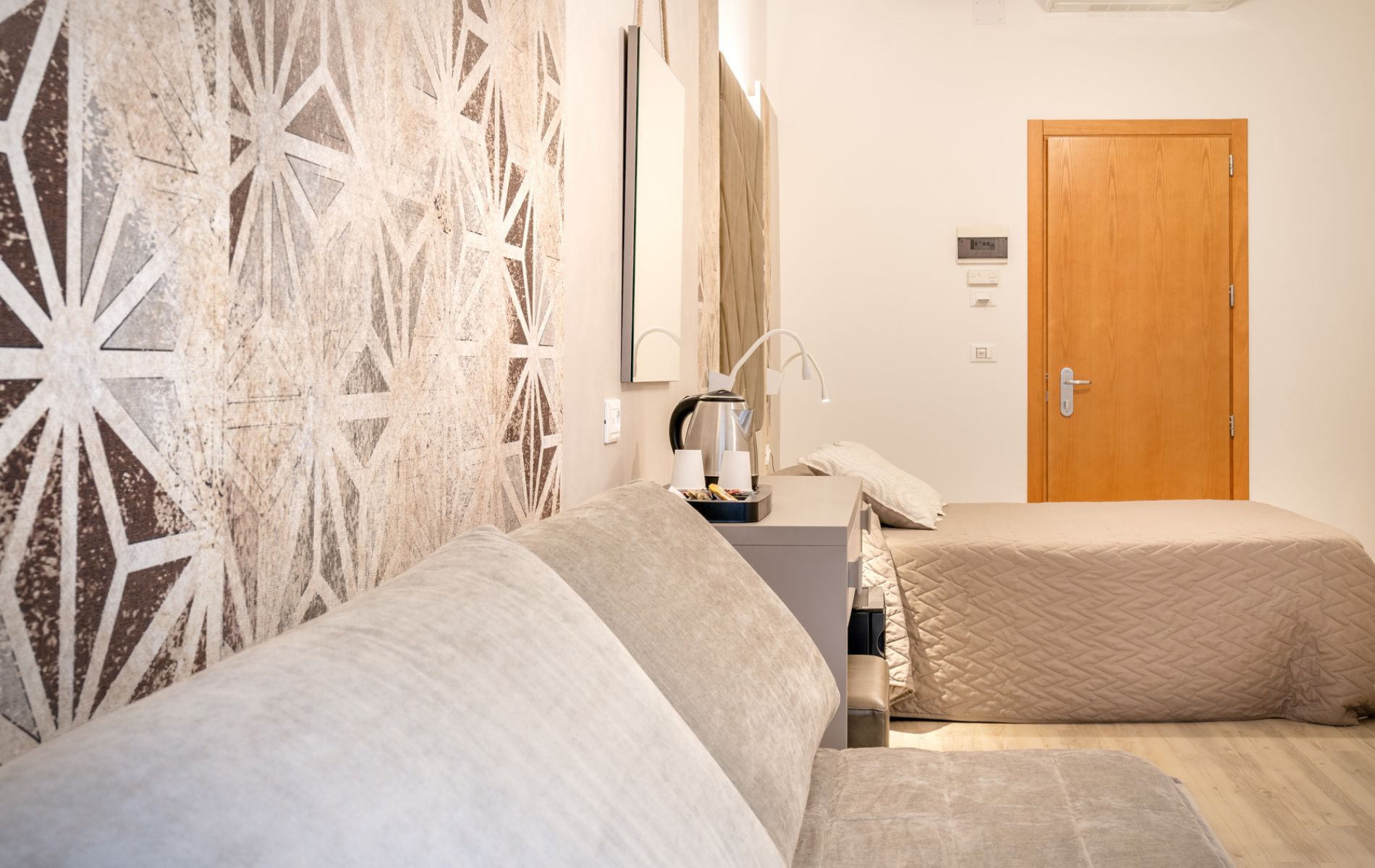 Vista d'insieme della Camera Vanilla presso l'Hotel All'Orologio a Caorle con letto matrimoniale e arredi moderni.